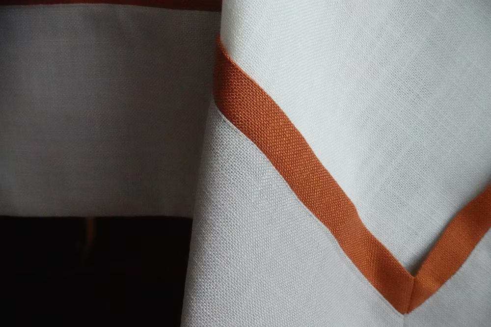 22 Maggio Istanbul Calvino Designer Table Cloth-Close-up of fabric with a brown stripe on a white background