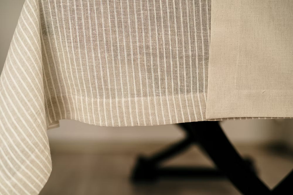 22 Maggio Istanbul Suolo Linen Tablecloth-Close-up of beige fabric with subtle pattern on a blurred background