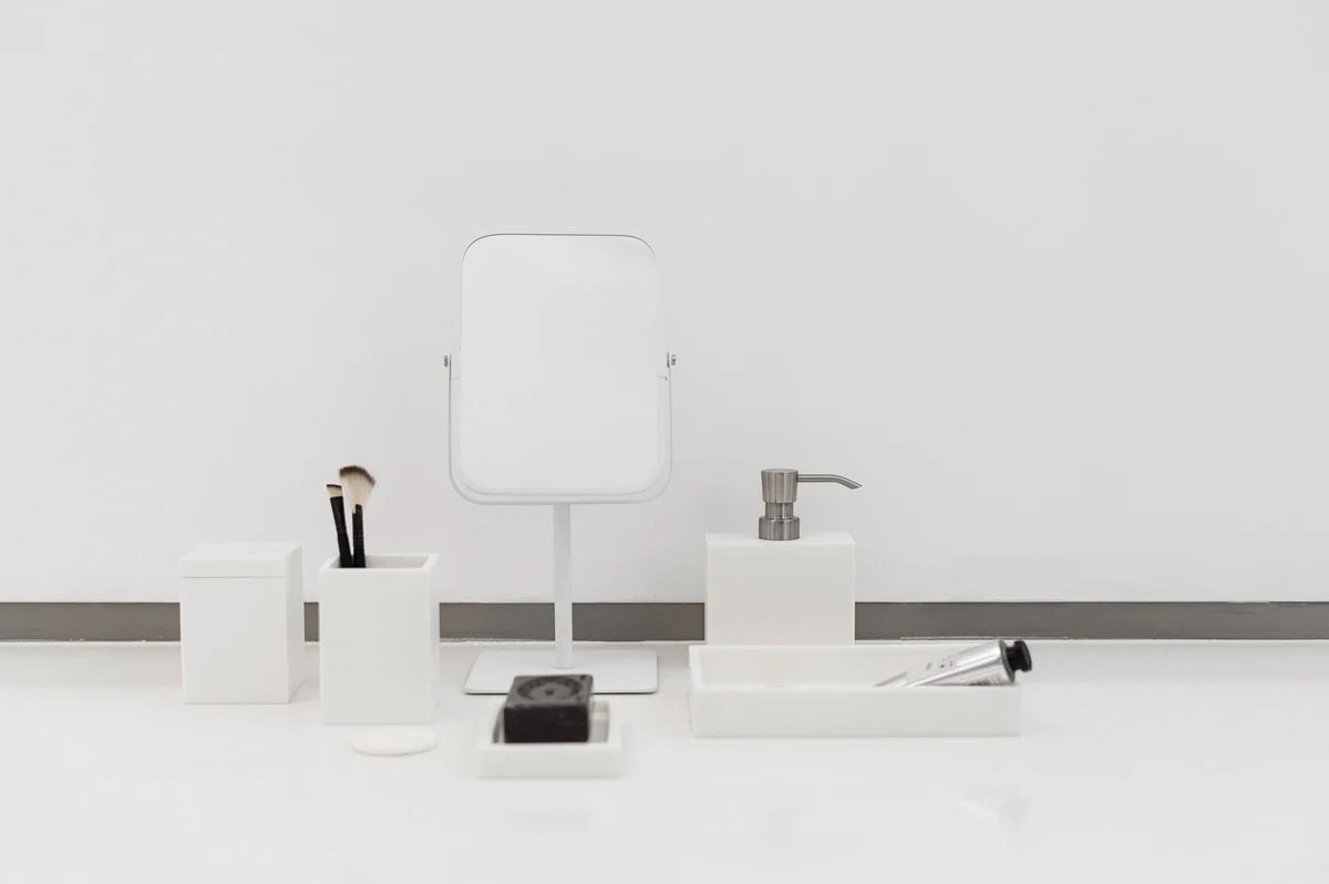Aquanova Moon Mirror-White bathroom accessories including a soap dispenser, mirror, and toiletries on a white surface.-moon-mirror-on-dresser-with-mirror-dubai-beauty-lounge-crescent-dressing-table-mirror-uae-vanitymoon-wall-mirror-arabic-home-decor-dubai