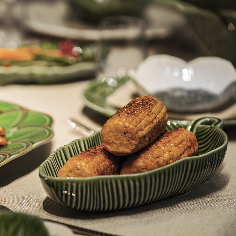 Bordallo Pinheiro Banana Leaf Bowl-Three roasted chestnuts on a green ceramic dish with a blurred background