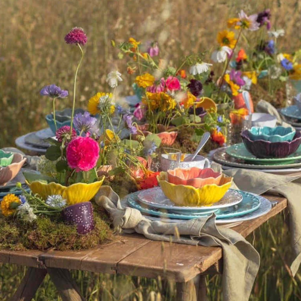 Bordallo Pinheiro Flora Bowl-Colorful outdoor table setting with flowers and plates in a natural setting