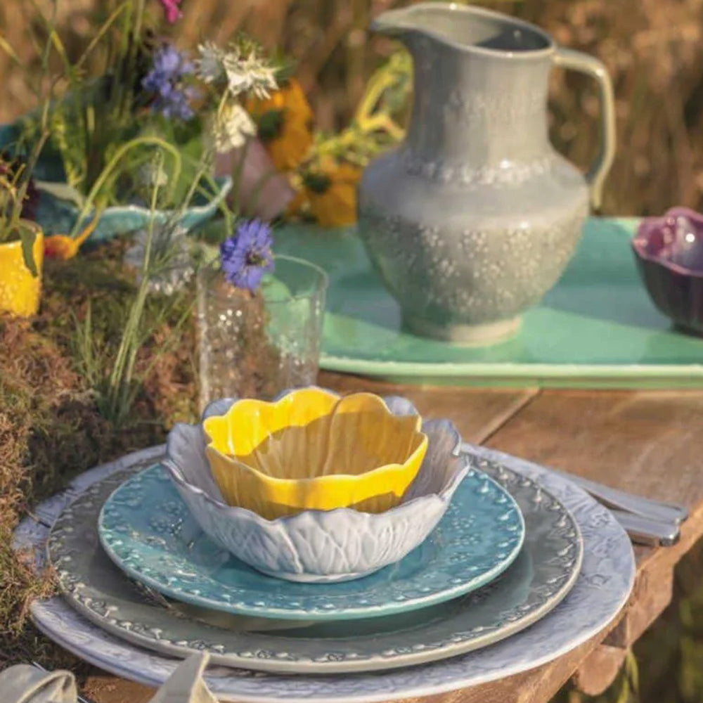 Bordallo Pinheiro Flora Bowl-Decorative table setting with ceramic bowls and pitcher on a wooden surface.