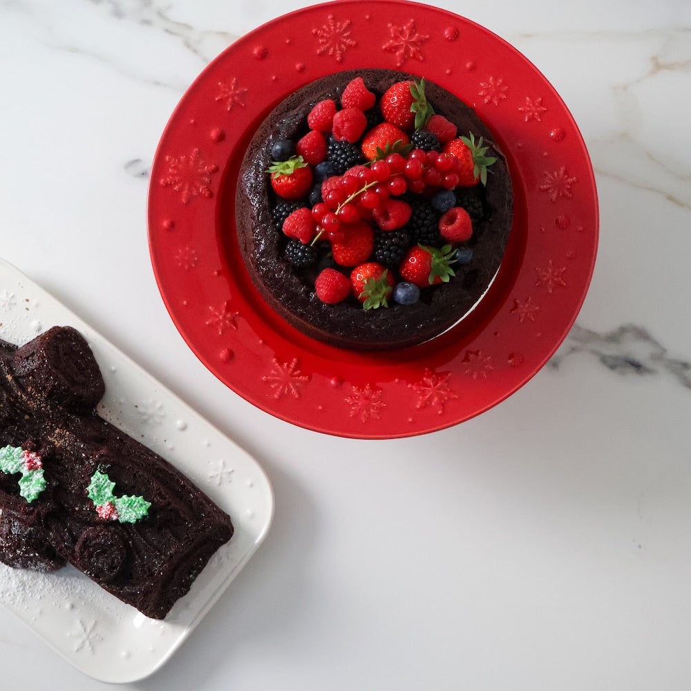 Bordallo Pinheiro Snowflakes Cake Stand-Chocolate cake with berries on a red plate, served on a marble surface