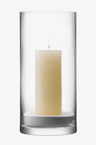 Candle in a clear glass holder on a white background