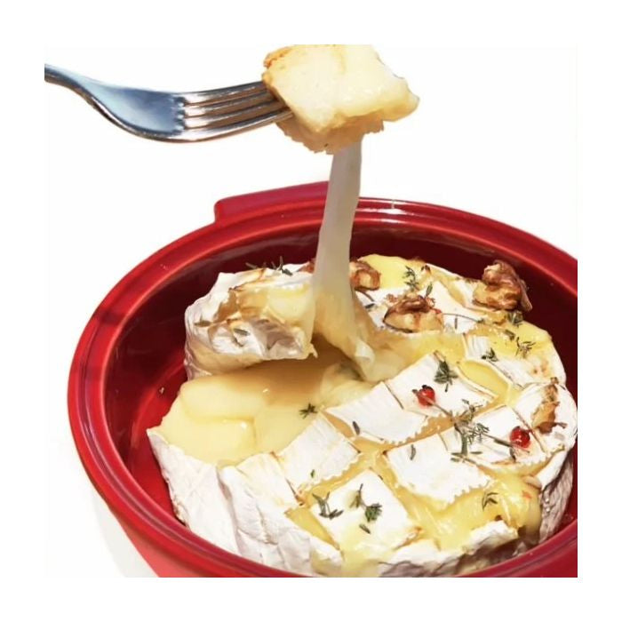 Emile Henry Cheese Baker-Baked Brie with a fork lifting a piece, served in a red dish on a white background