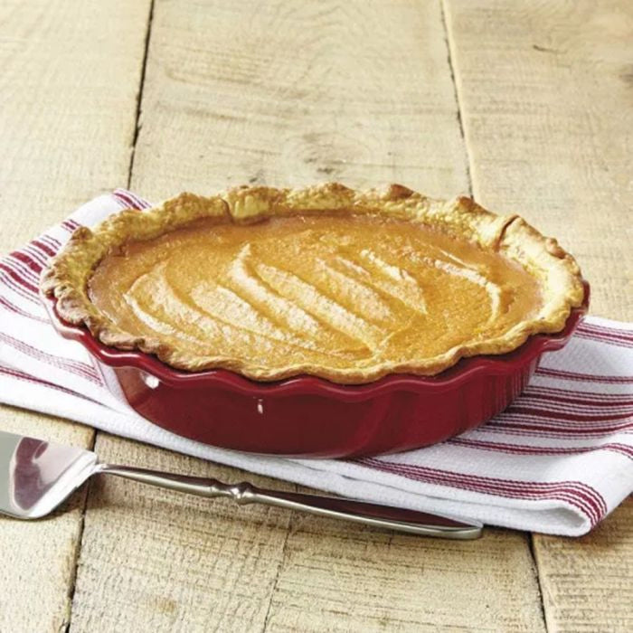 Emile Henry Pie Dish, 26cm-Pumpkin pie in a red pie dish on a wooden table with a striped cloth