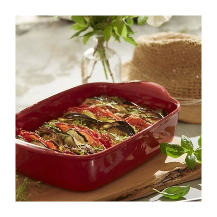 Emile Henry Rectangular Oven Dish-Red ceramic baking dish with roasted vegetables on a wooden surface.