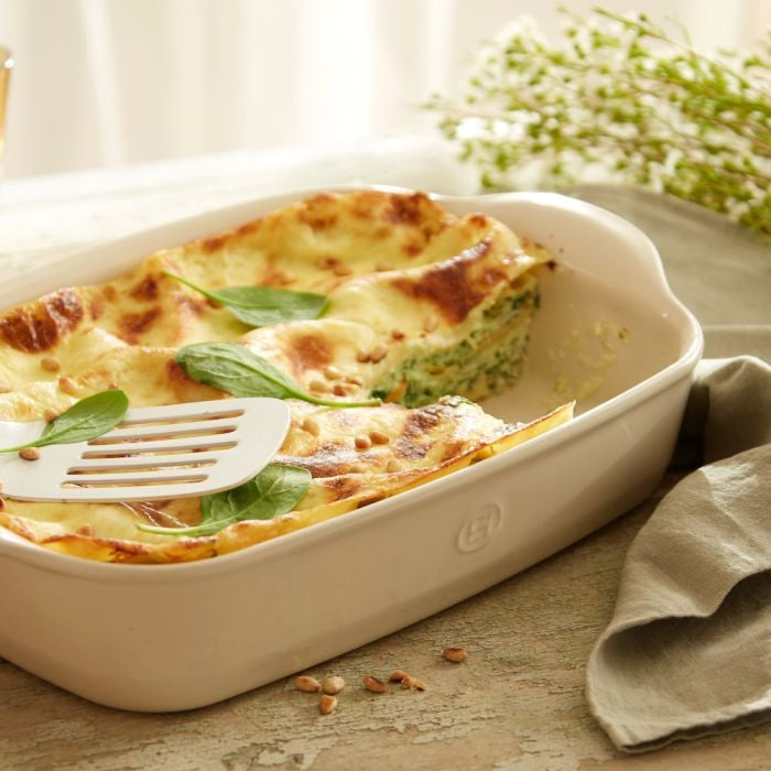 Emile Henry Rectangular Oven Dish-Baked dish with spinach and cheese in a white baking dish on a wooden table.