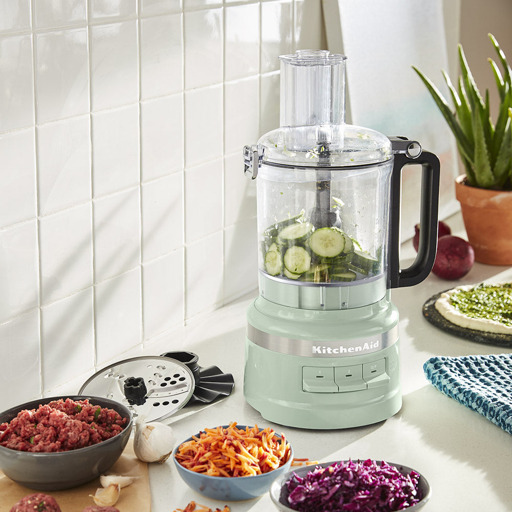 KitchenAid food processor on a kitchen counter with ingredients around