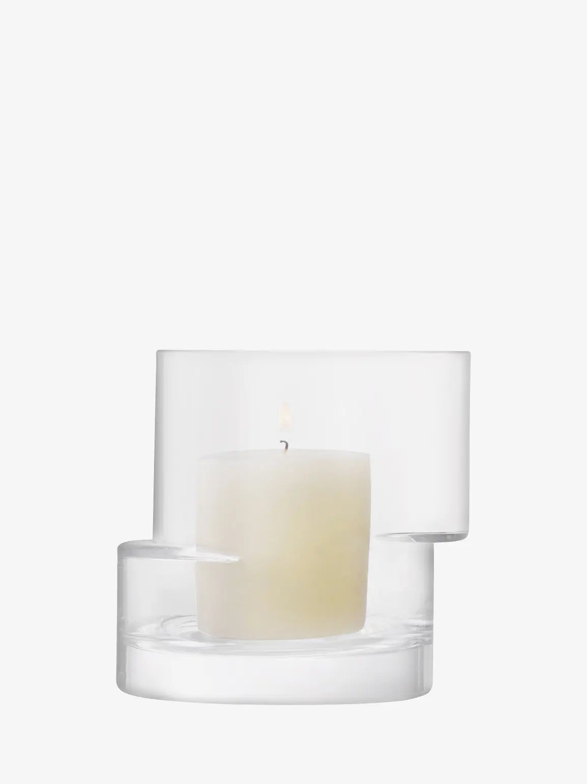 White candle in a clear glass holder on a white background