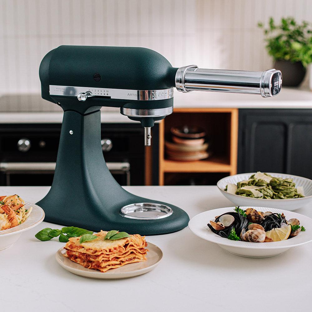 KitchenAid Green stand mixer on a kitchen counter with plates of food