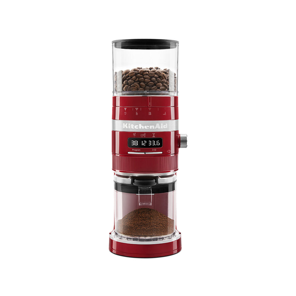 Red KitchenAid coffee grinder with coffee beans on a white background