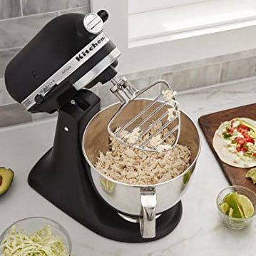 KitchenAid stand mixer with a bowl of food on a kitchen counter.