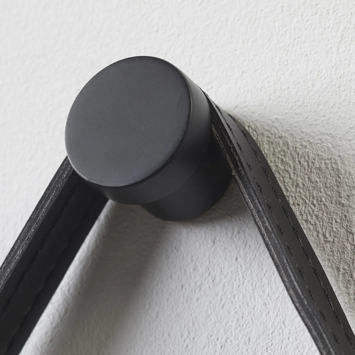 Black metal bracket attached to a white wall