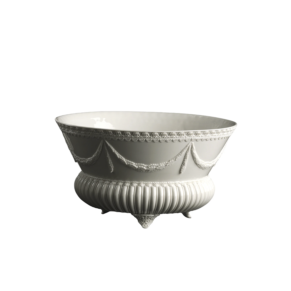 A white porcelain planter with ornate designs around the rim and base, displayed against a plain background.