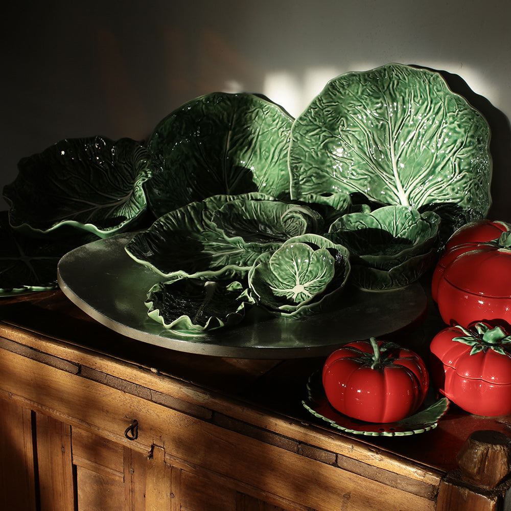 Cabbages and red tomatoes on a wooden surface with a dark background