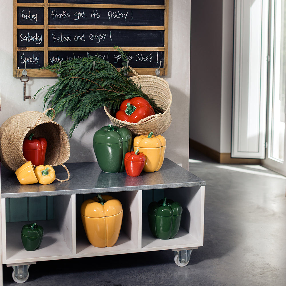 Colorful ceramic pepper shakers on a metal shelf with decorative items.