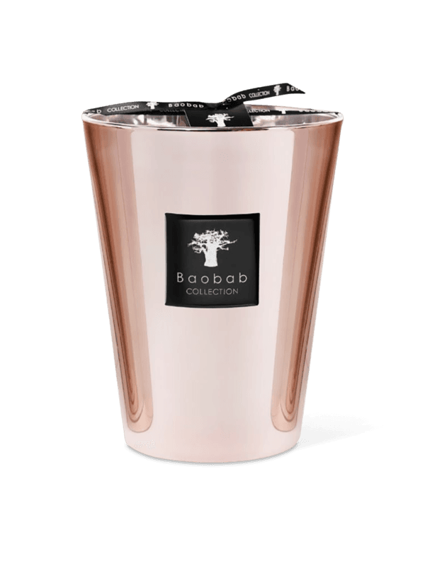 A pink metallic candle holder with a candle inside, featuring a clear glass enclosure and a black label with the brand name 'Baobab Collection'.