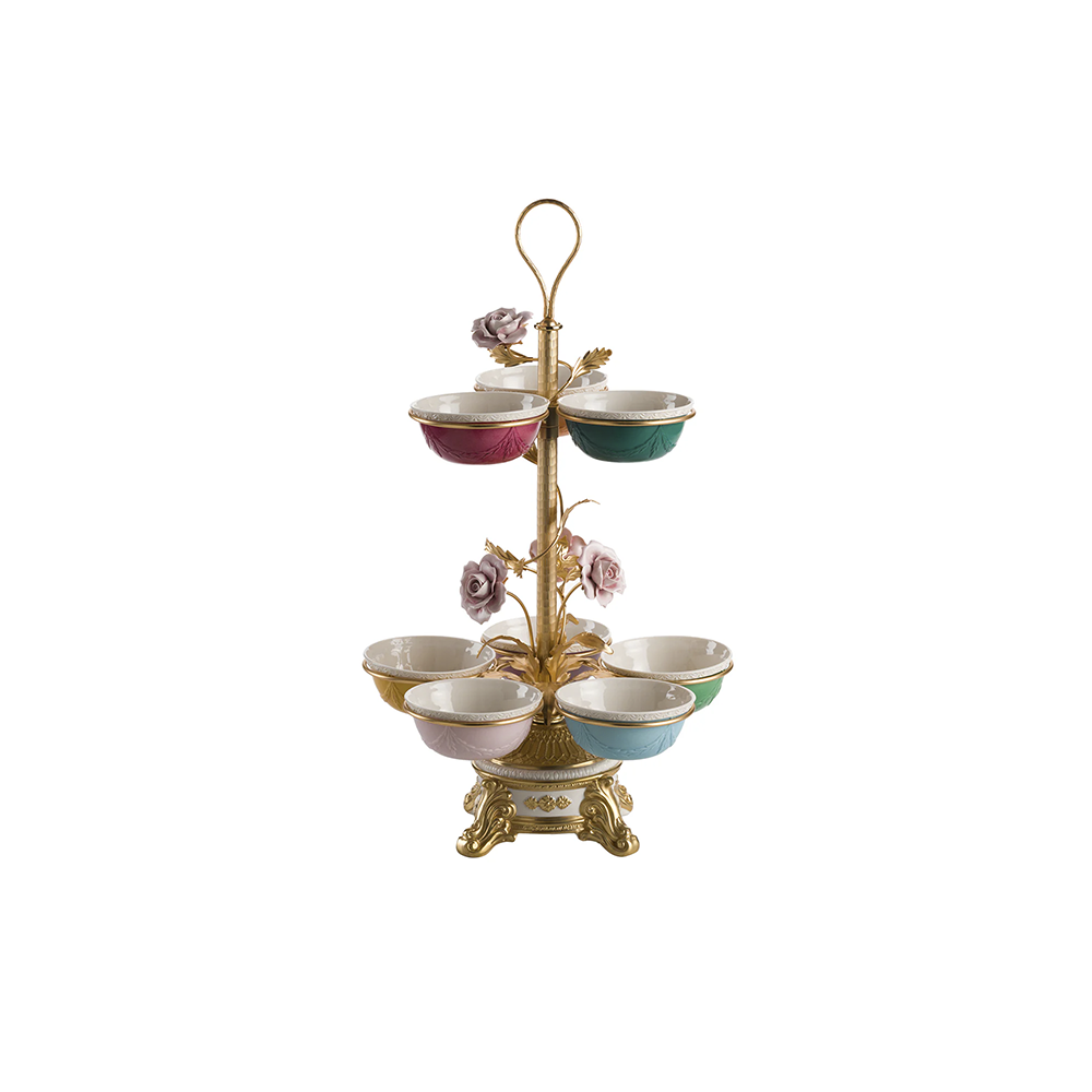 A multi-tiered snack holder with gold-colored metal frame and white, pink, and green ceramic bowls, adorned with delicate floral designs.