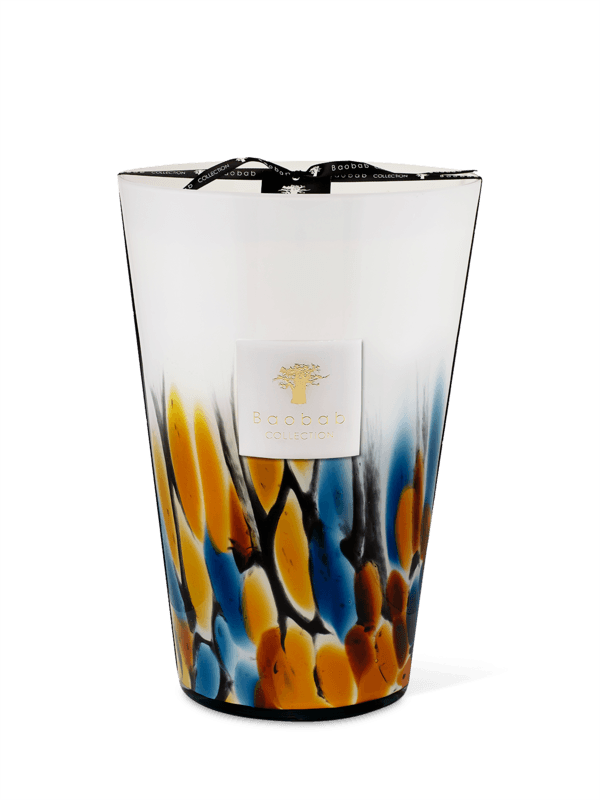 A colorful hand-blown glass candle with a lid, featuring a mix of blue and yellow colors and a label with the brand 'Baobab Collection'.