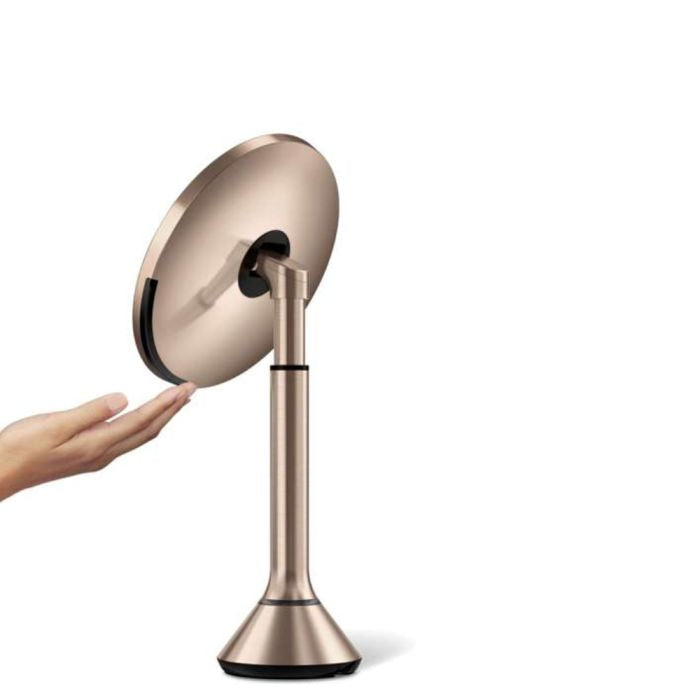 simplehuman Round Sensor Mirror -Rose gold handheld mirror held by a hand on a white backgrounddresser-with-mirror-uae-beauty-lounge-dressing-table-mirror-dubai-luxury-vanity-wall-mirror-for-dubai-bedrooms