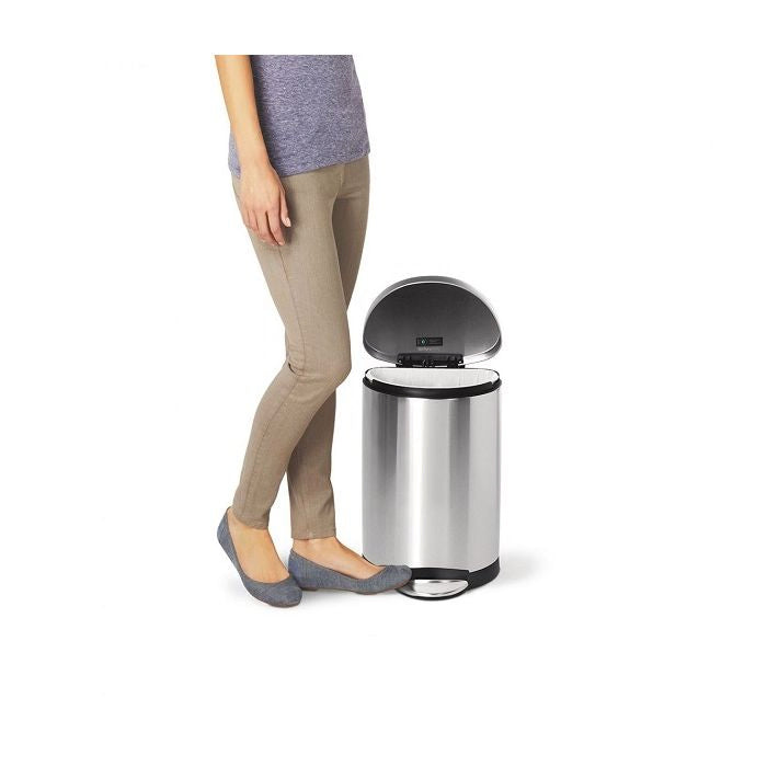 simplehuman Semi Round Bin, 10L-Person standing next to a stainless steel trash can on a white background