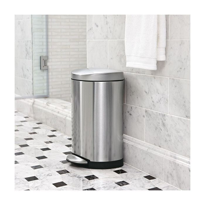 simplehuman Semi Round Bin, 10L-Stainless steel trash can in a bathroom with marble tiles and a towel.