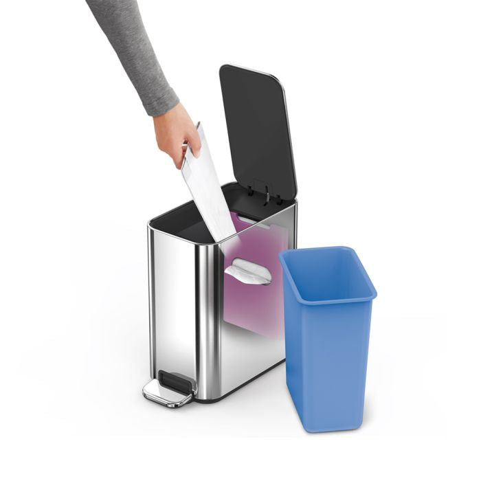 Person disposing of a used pad into a trash can with a blue liner.