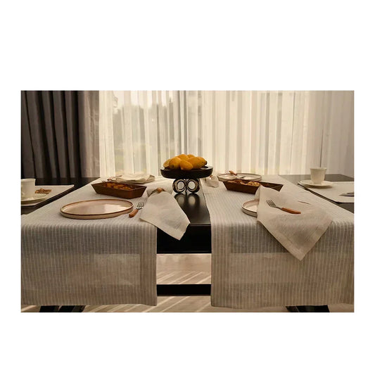 Luxury dinner set arranged on a minimalist dining table with beige linens and soft natural light