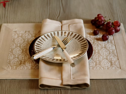 22 Maggio Istanbul Latte Placemat Set of 4-Table setting with a plate, cutlery, and grapes on a patterned placemat.