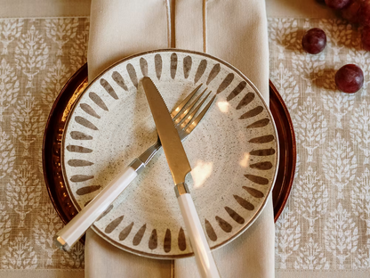 22 Maggio Istanbul Latte Placemat Set of 4-Set table with a decorative plate, knife, and fork on a patterned tablecloth.