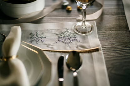 22 Maggio Istanbul Le Alpi  New Year Placemat Set of 4-Close-up of a table setting with silverware, plates, and a decorative napkin on a wooden table.