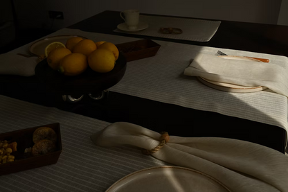 22 Maggio Istanbul Terreno Beige Linen Napkin Set of 4-Dining table setting with lemons on a plate, cutlery, and a napkin.