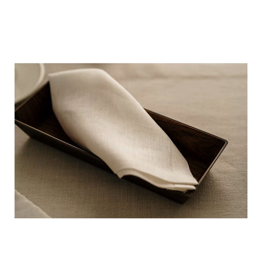 22 Maggio Istanbul Terreno Beige Linen Napkin Set of 4-Napkin on a black rectangular plate on a beige surface