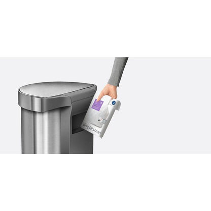 Simplehuman Semi Round Sensor Bin With Liner Pocket-Person holding a Simplehuman trash can liner next to a trash can on a white background