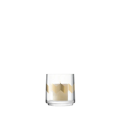 A clear glass lantern/vase with gold chevron motifs and a textured pillar candle inside.