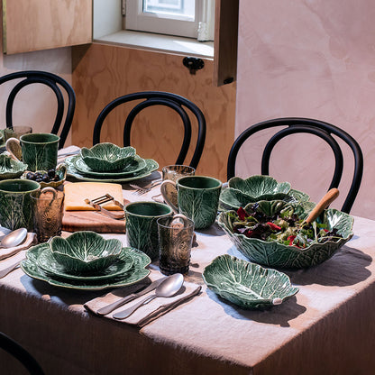 Bordallo Pinheiro Cabbage Chip & Dip Bowl-Dining table set with green leaf-patterned dishes and utensils in a home setting.