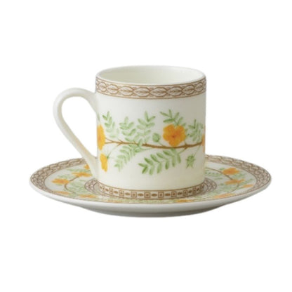 Collation formation curation A white ceramic cup with green and yellow floral patterns, accompanied by a matching saucer.