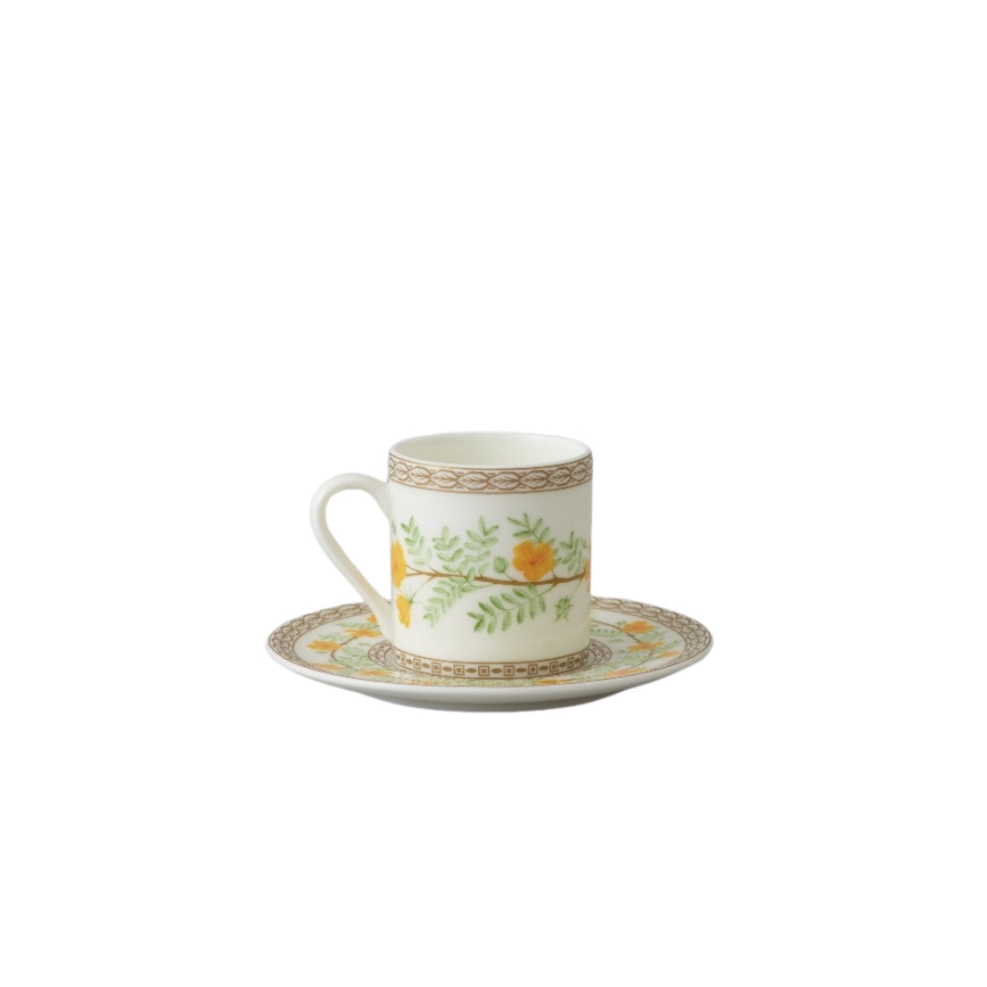Collation formation curation A white ceramic cup with green and yellow floral patterns, accompanied by a matching saucer.