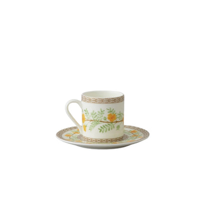 Collation formation curation A white ceramic cup with green and yellow floral patterns, accompanied by a matching saucer.