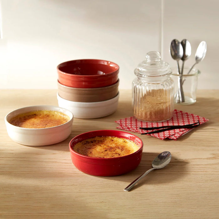 Emile Henry Crème Brûlée Dishes, Set of 2-Red and white ceramic bowls with créme bréleé on a wooden table.