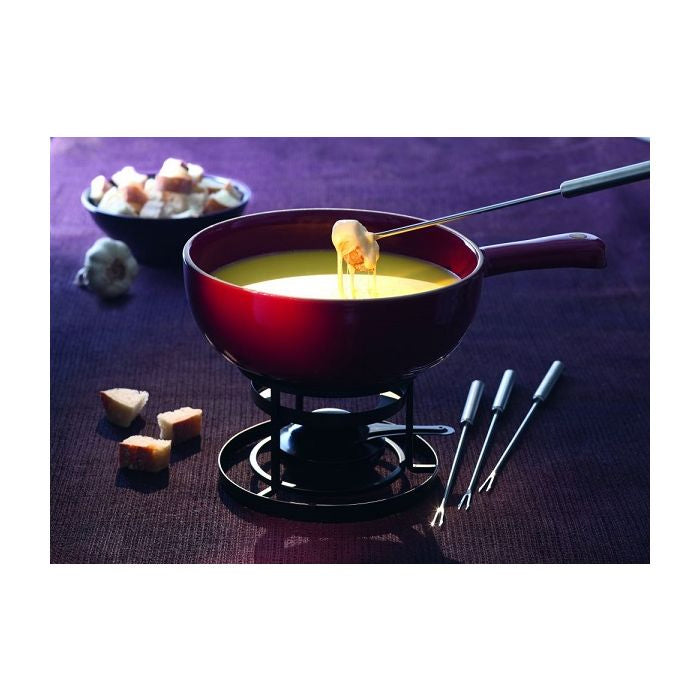 Emile Henry Fondue Set-Red fondue pot with cheese fondue, bread cubes, and fondue forks on a purple surface.