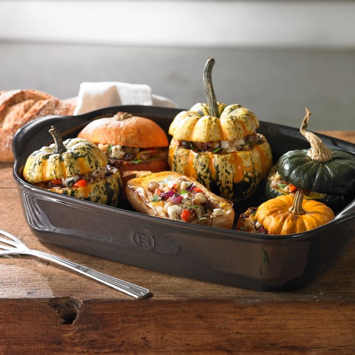Emile Henry Rectangular Oven Dish-Stuffed pumpkins in a baking dish on a wooden surface with bread in the background