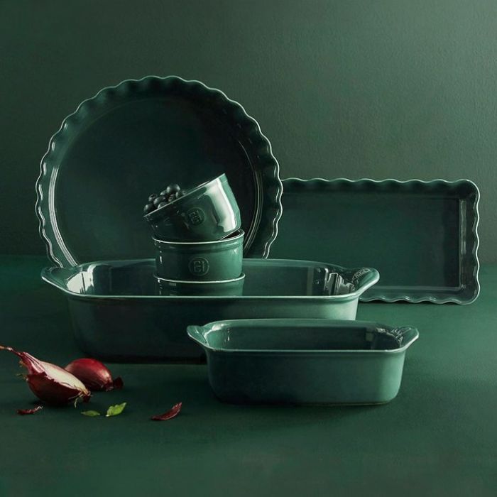 Emile Henry Rectangular Oven Dish-Set of green ceramic cookware including a pie dish, loaf pan, and baking tray on a dark green background.