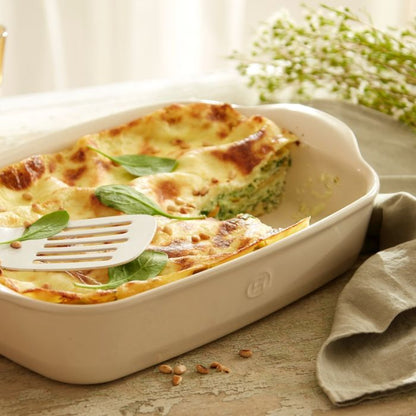 Emile Henry Rectangular Oven Dish-Baked dish with spinach and cheese in a white baking dish on a wooden table.