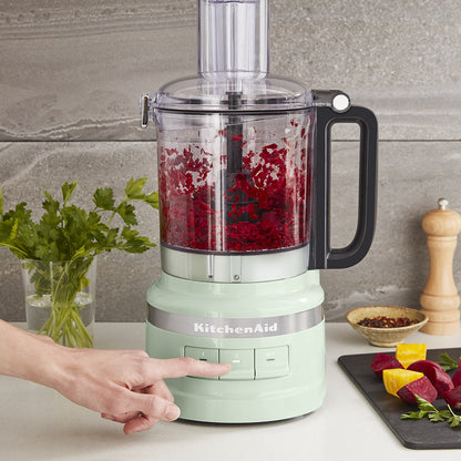 KitchenAid food processor with red vegetables on a kitchen counter