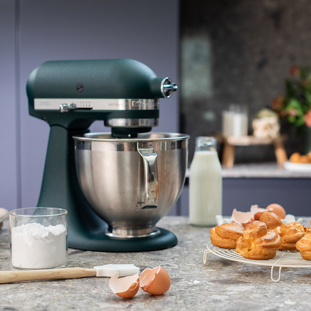 KitchenAid Green stand mixer on a kitchen counter with pastries and ingredients