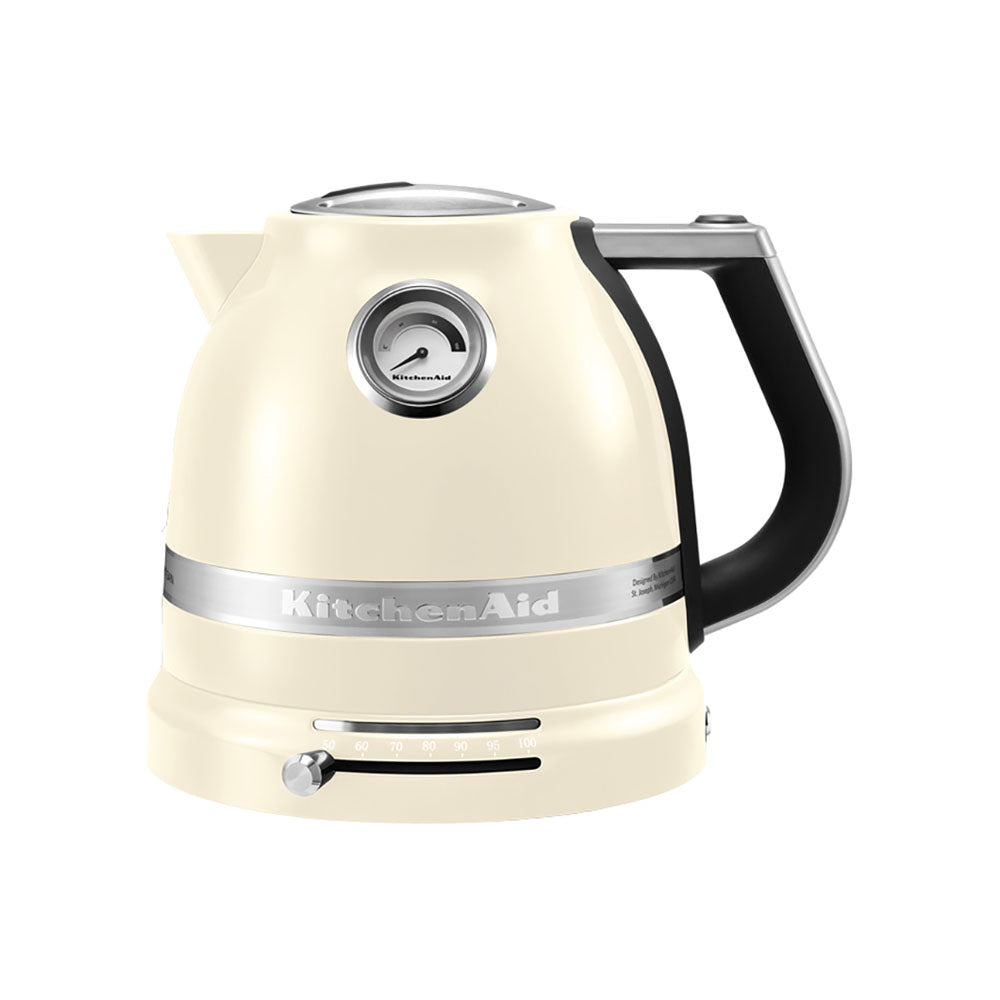 Cream-colored KitchenAid kettle with a black handle on a white background