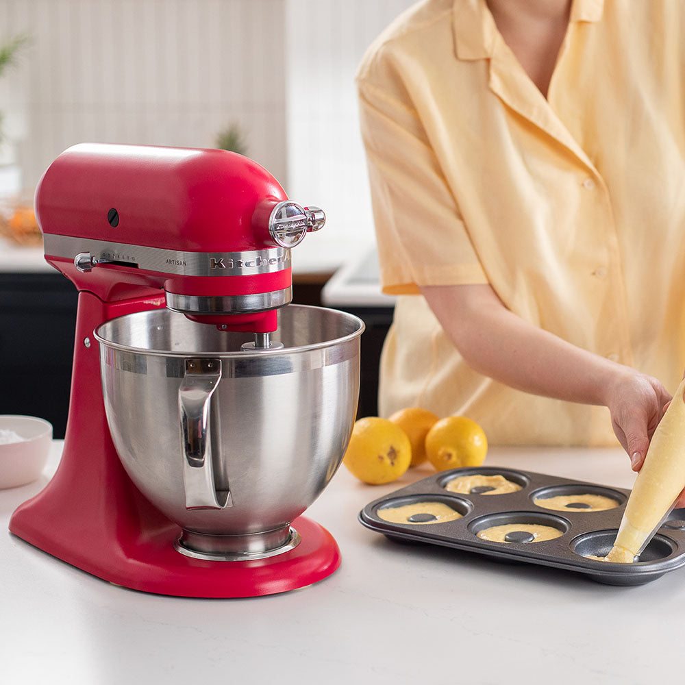 Red stand mixer with a person baking in the background