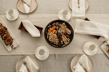 Lino Linen Table Runner-Dining table set with plates, cups, and a bowl of assorted nuts and dried fruits.